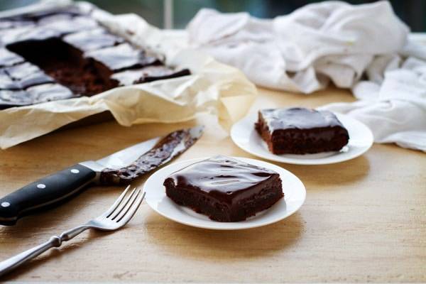 Fudgy chocolate cake bars on a white plate.