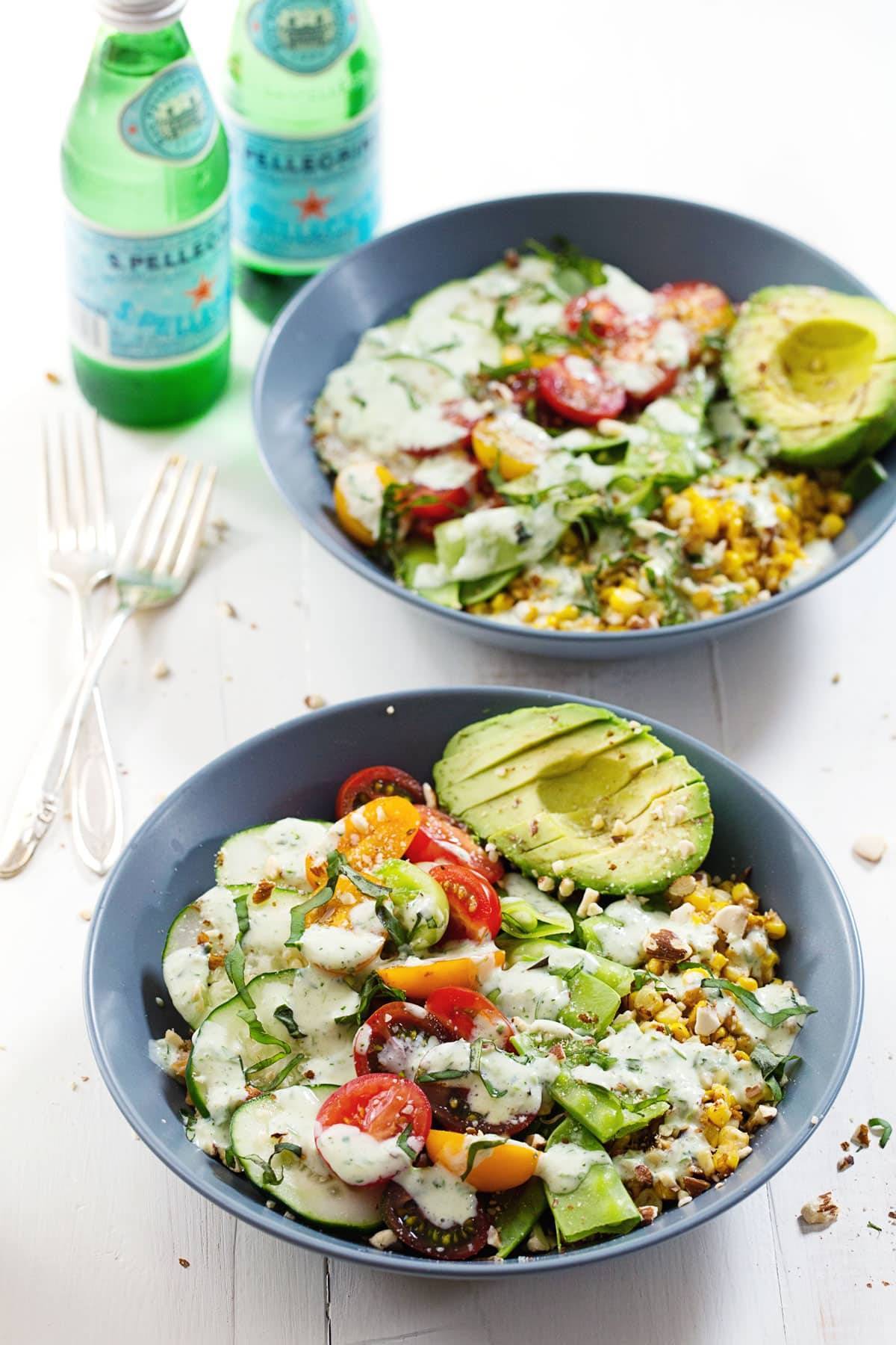 Rainbow Veggie Bowls with Jalapeño Ranch in blue bowls with sparkling water and forks.