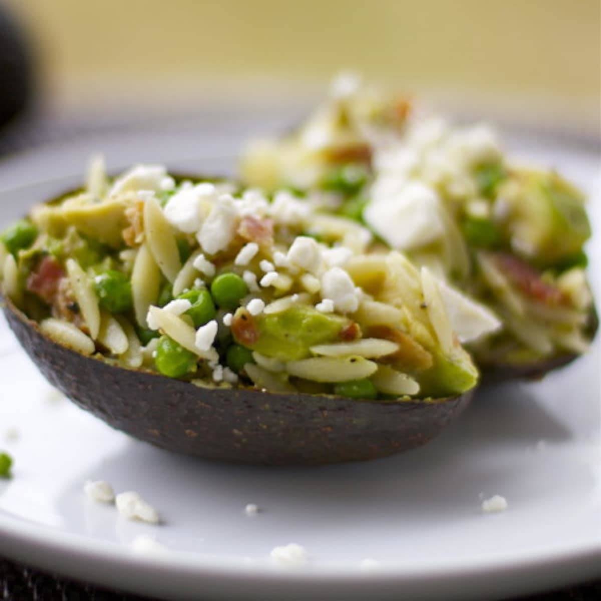Avocado Bacon Orzo with feta cheese served in an avocado peel.