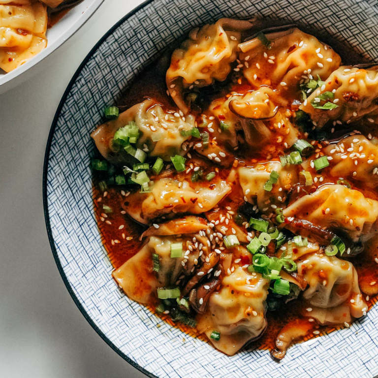 Wontons in a chili sauce in a bowl.