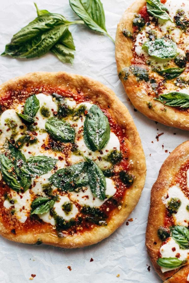Fried Pizzas on parchment paper with basil.